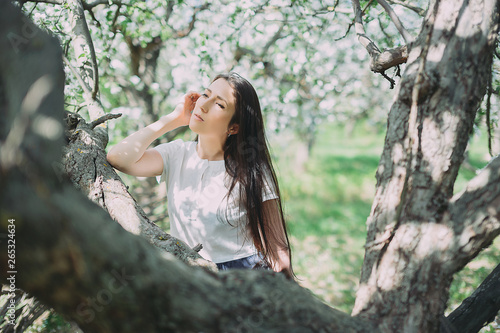 Beautiful girl posing in the blooming garden. apple, cherry photo