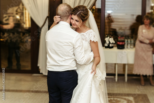 happy gorgeous bride and stylish groom dancing in rich restaurant with tender feelings, romantic moment