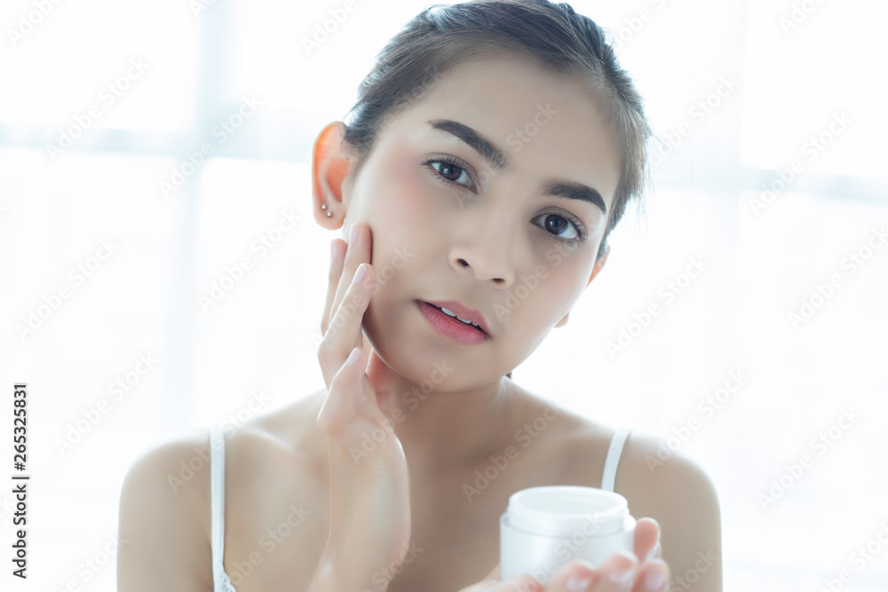 A beautiful woman asian using a skin care product, moisturizer or lotion taking care of her dry complexion. Moisturizing cream in female hands . A beautiful woman asian using a skin care product, moisturizer or lotion taking care of her dry complexion. Moisturizing cream in female hands .