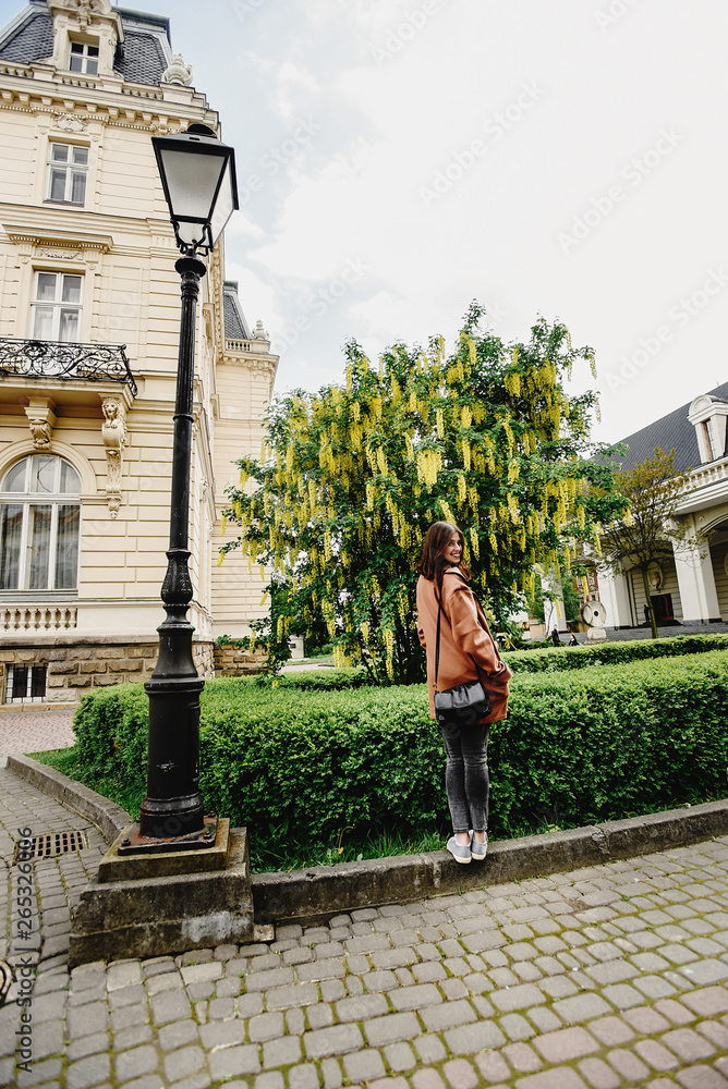 Fototapeta premium stylish gorgeous hipster girl traveling in europe city in sunny spring time