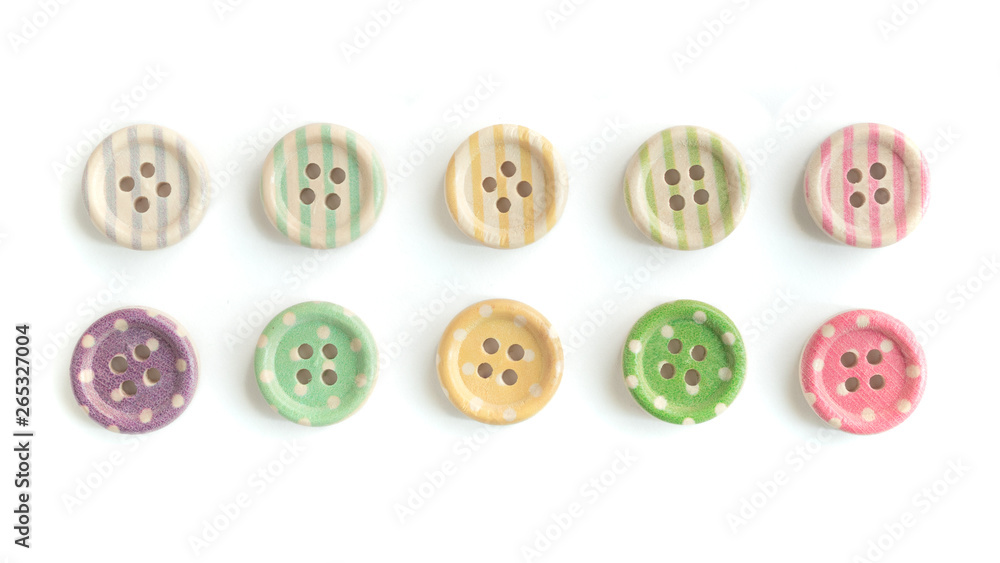 Obraz premium Wooden buttons with colorful stripes and colorful dots on a white background