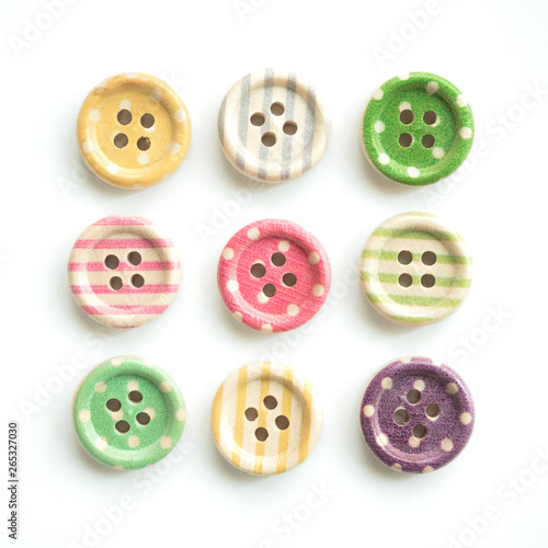 Wooden buttons with colorful stripes and colorful dots on a white background