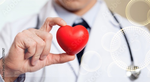 Young man doctor holding red heart