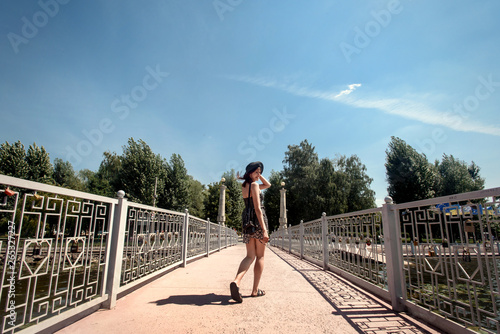 happy stylish woman walking and laughing at sunny pier, summer travel concept, space for text, cheerful moment