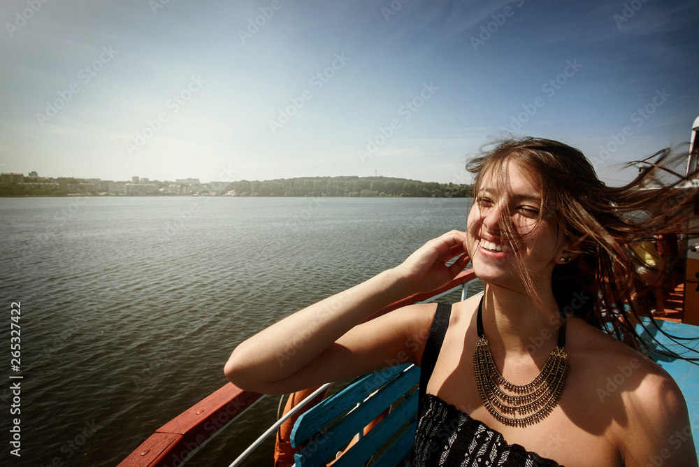 happy stylish woman hipster with windy  hair having fun on deck of a boat, summer travel concept, space for text