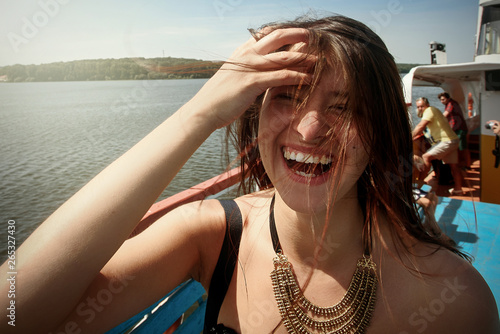 happy stylish woman hipster with windy  hair having fun on deck of a boat, summer travel concept, space for text © sonyachny
