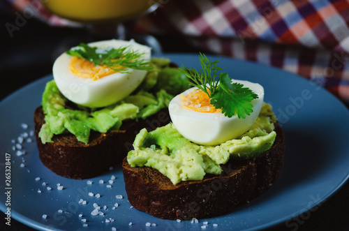 Healthy healthy snack (breakfast) - sandwich with avocado and egg on a gray plate.