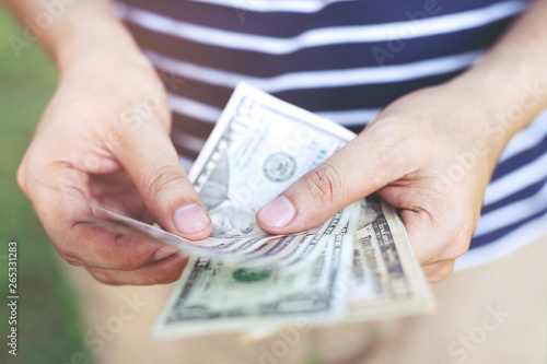 close up young man standing hand hold Count the money spread of cash. concept finance Saving money.