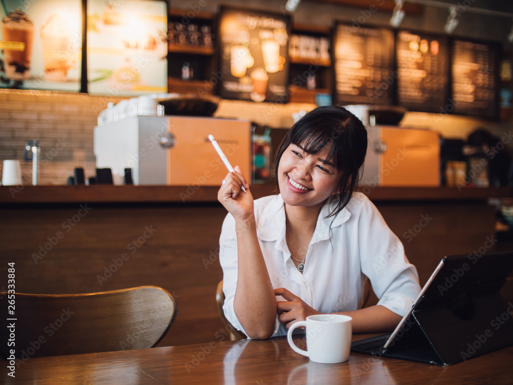 Asian woman drinking coffee in cafe and using laptop computer for working business online marketing