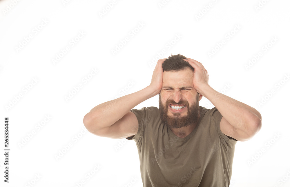 Feeling terrible headache. Portrait of bearded man is standing and touching his temples while suffering from pain. Feeling terrible headache. Portrait of bearded man is standing and touching his temples while suffering from pain.