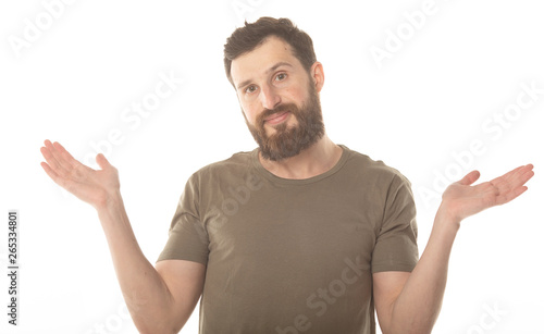 I don't know. Young bearded man isolated on white background being at a loss, showing helpless gesture with arm and hands. 