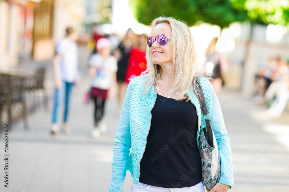 Attractive woman in sun glasses walking downtown