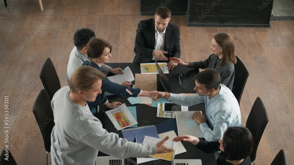 Successful end of business meeting. Shaking hands with partners. Open space office. Startup concept coworking team group happy people Successful end of business meeting. Shaking hands with partners. Open space office. Startup concept coworking team group happy people