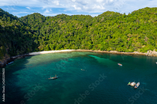 Aerial drone view of traditional longtail fishing boats in a bay on a small, tropical island (Cavern Island, Mergui, Myanmar)