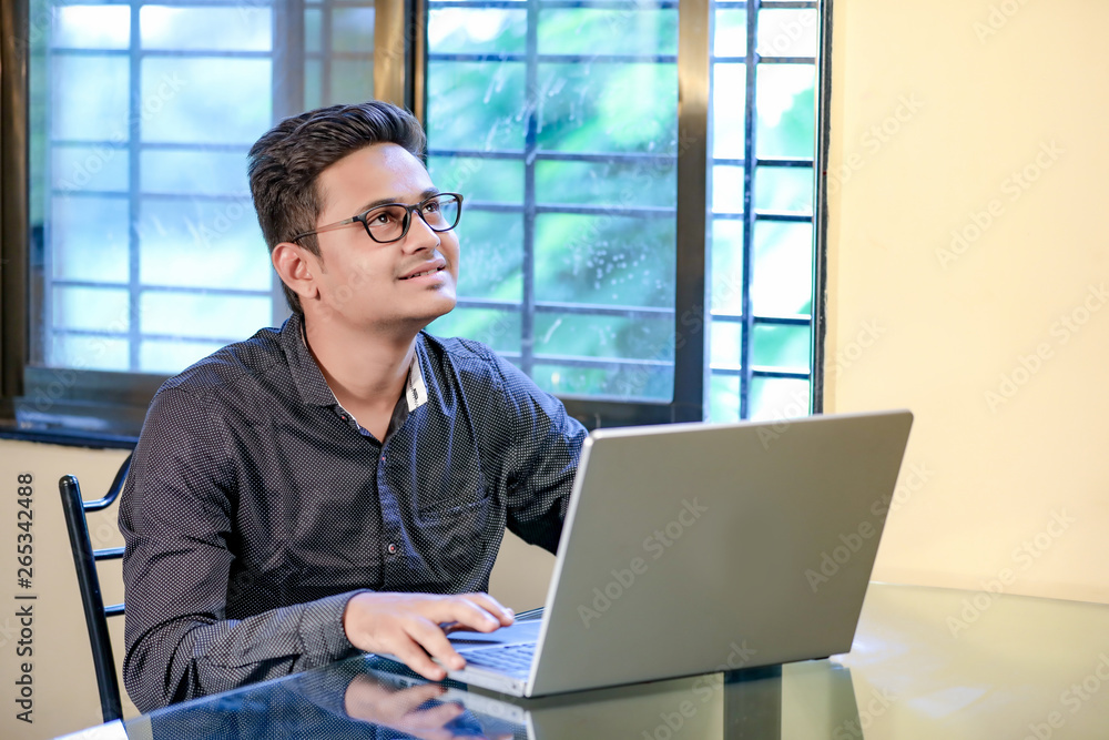Fototapeta premium Young indian man with laptop