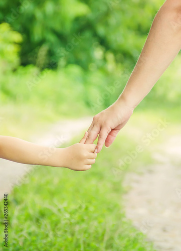 Mom and daughter are walking along the road holding hands. photo