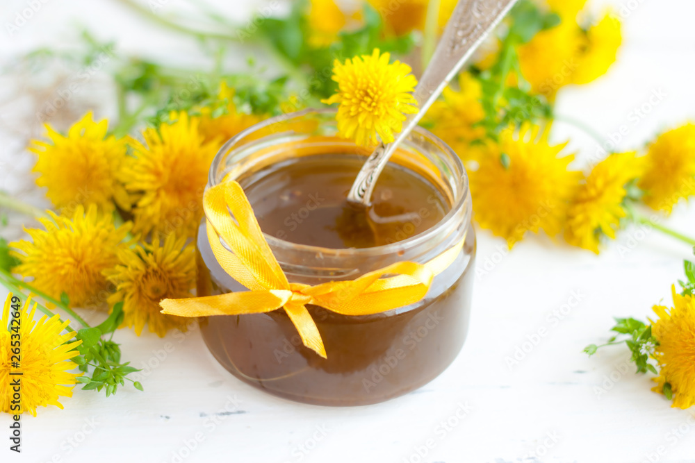 Glass jar of dandelion jam on a wooden table Glass jar of dandelion jam on a wooden table