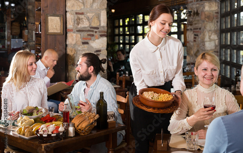 Young female waiter serving country restaurant guests © JackF