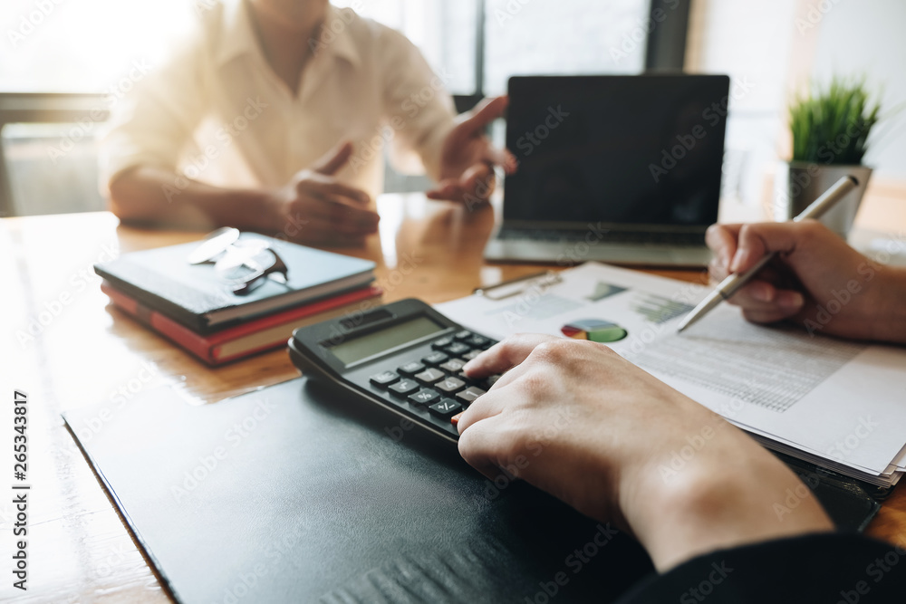 Business or Accountant people using calculator and laptop computer for discussion about profit, tax, financial Business or Accountant people using calculator and laptop computer for discussion about profit, tax, financial