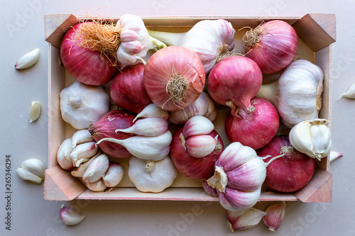 Young garlic and red onions in a vegetable box. Concept- organic vegetables, healthy food.