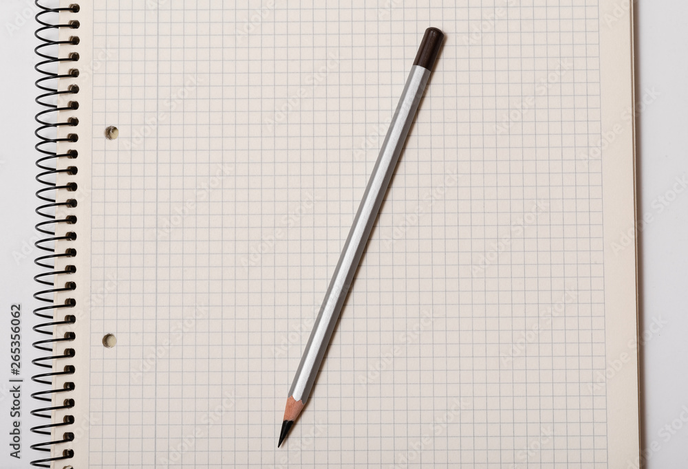 white checked notebook and gray pencil on white background white checked notebook and gray pencil on white background