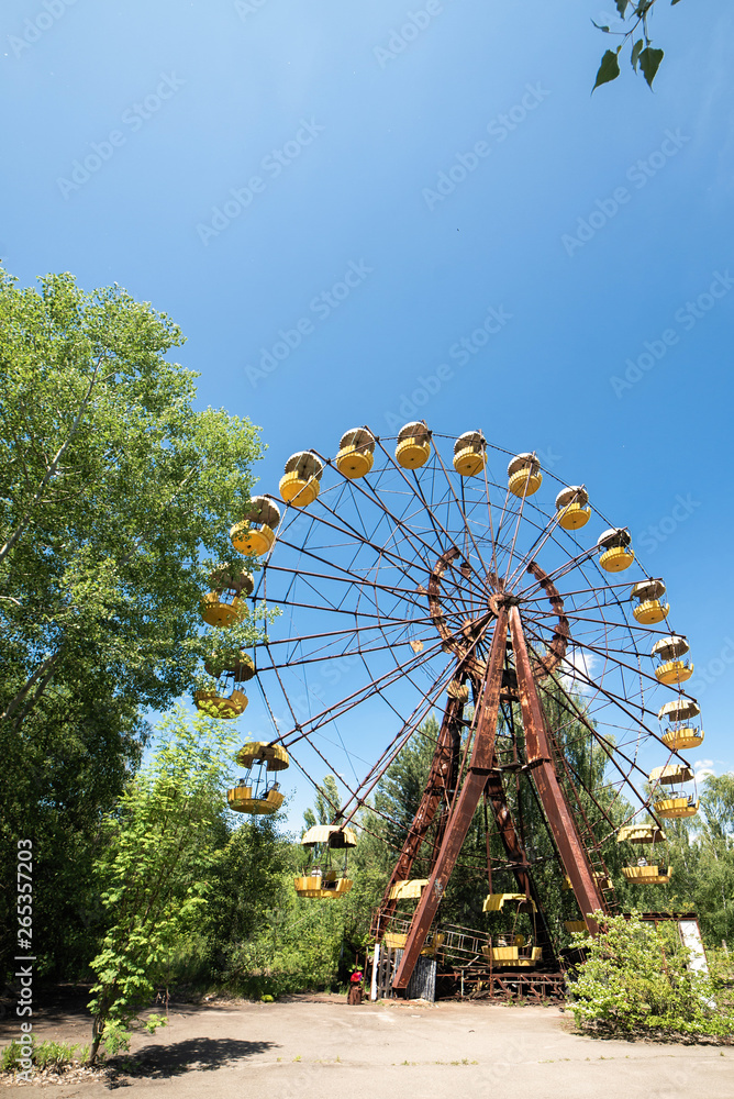 Abandoned carousel and abandoned ferris at an amusement park in the center of the city of Pripyat, the Chernobyl disaster, the exclusion zone, a ghost town