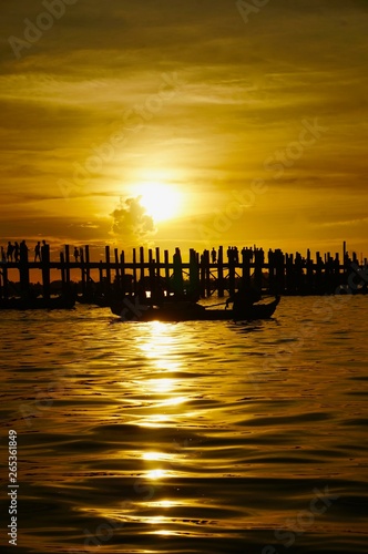 Sunset over U Bein bridge with a boat, Mandalay