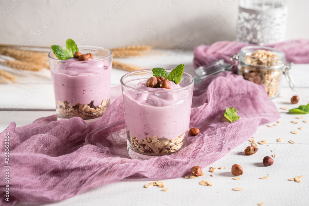 Healthy breakfast parfait with yogurt, granola and nuts in glass