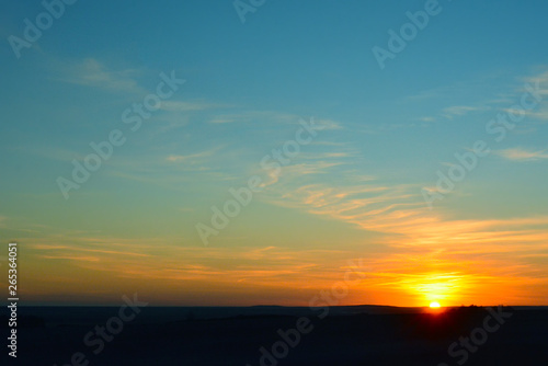 Beautiful sunset over the green field  in the spring evening