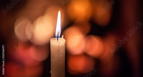 Lighted candle on background with bokeh