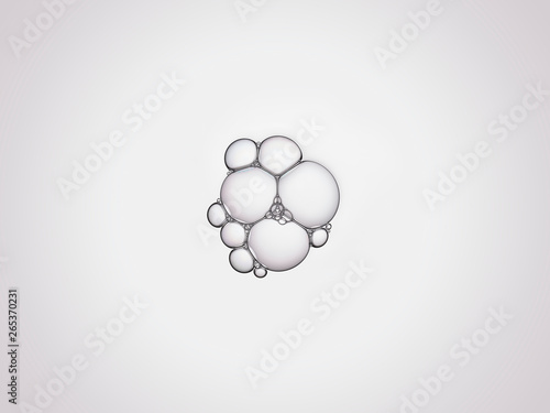 Bulles de savon en macrophotographie, bulles de taille variable connectées entre elles sur un fond neutre