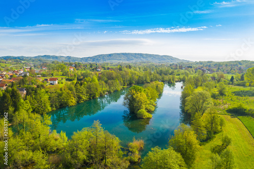 Beautiful rural landscape, Croatian river Mreznica and village of Belavici from air, peaceful water surface and woods