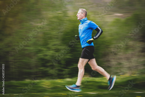 Senior Man in 50s Running with motion panning blurred background