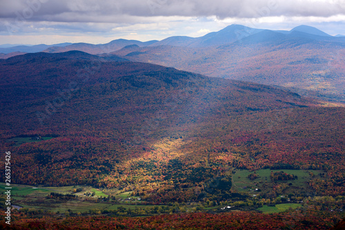 A Sunbeam Shines Through The Clouds To The Autumn Coloured Forest Below; Dunham, Quebec, Canada photo