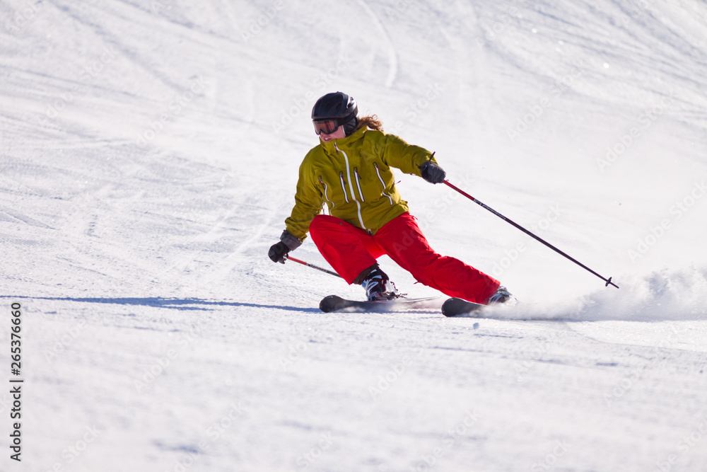 Young woman downhill skiing on an open slope at a ski resort in the Canadian Rocky Mountains, Alberta