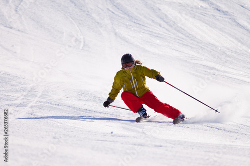 Young woman downhill skiing on an open slope at a ski resort in the Canadian Rocky Mountains, Alberta