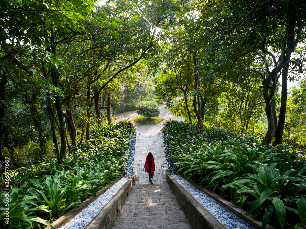 A woman walks down stairs surrounded by lush foliage, Ananda Hotel and Spa; Uttarakhand, India A woman walks down stairs surrounded by lush foliage, Ananda Hotel and Spa; Uttarakhand, India
