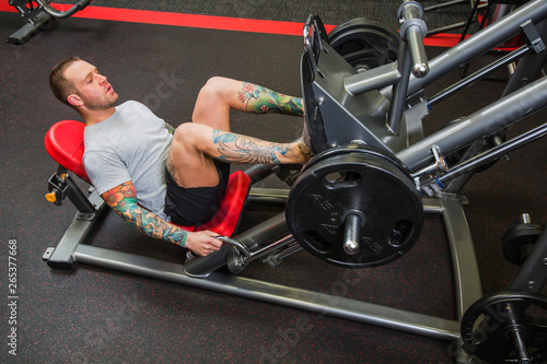 A young man doing leg presses at a fitness facility; Spruce Grove, Alberta, Canada photo