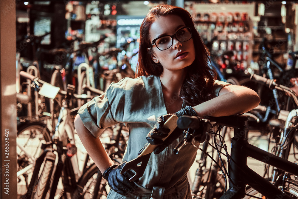 Young attractive worker is chilling after fixing customer's bicycle at workshop.