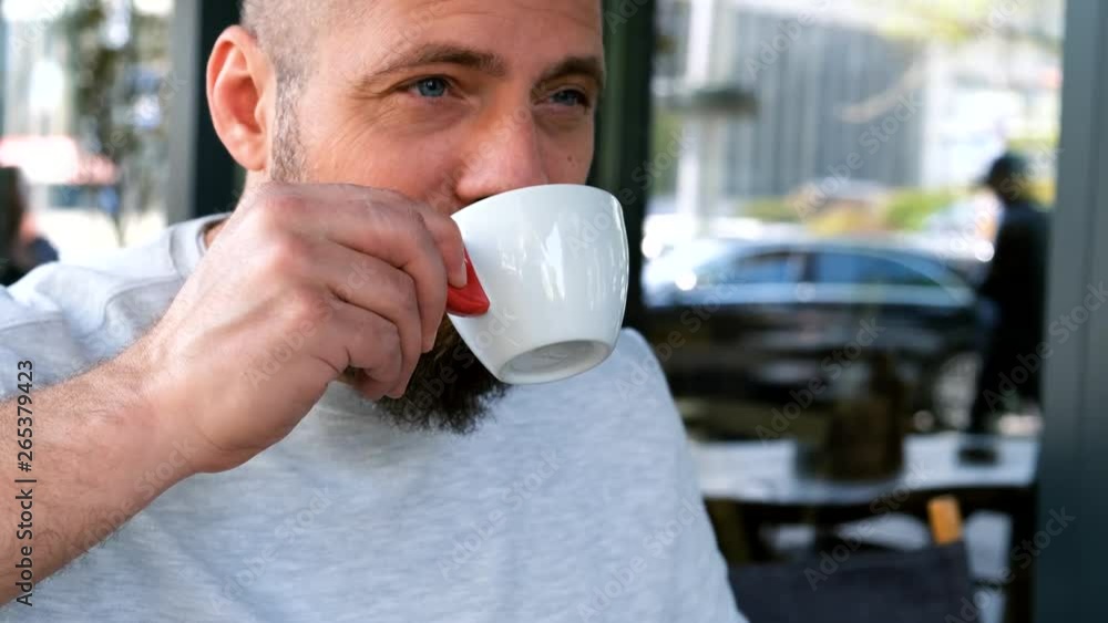Handsome bearded man enjoys drinking a cup of coffee Handsome bearded man enjoys drinking a cup of coffee