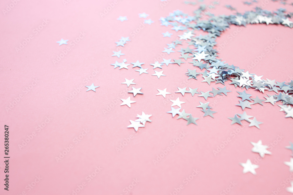 Star-shaped confetti scattered on a pink background. Celebration and party, concept. Copy space