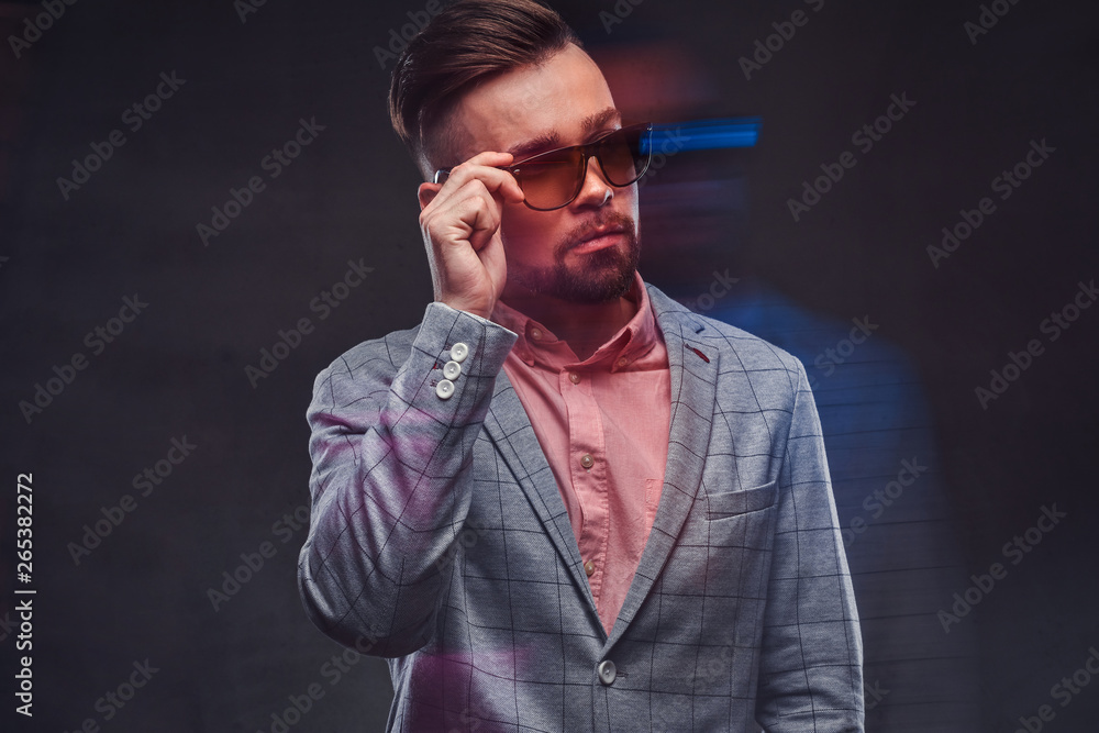 Movement photo of attractive smart man in checkered blaze, sunglasses and pink shirt. Movement photo of attractive smart man in checkered blaze, sunglasses and pink shirt.