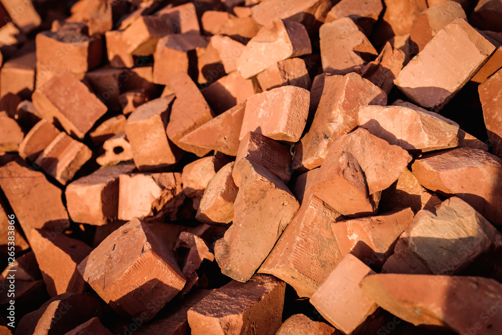 A pile of broken red building bricks is scattered on the ground. A pile of broken red building bricks is scattered on the ground.