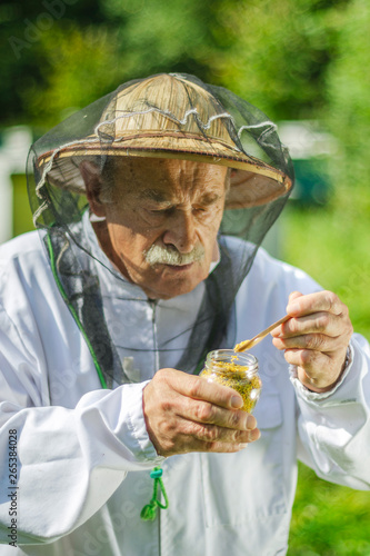 senior apiarist checking his bee pollen in apiary