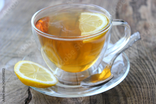 Cup of tea with lemon on wooden background. Copy space for your text.