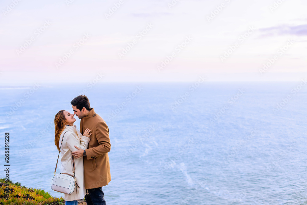 A close-up of a guy hugs a girl who has closed her eyes and they