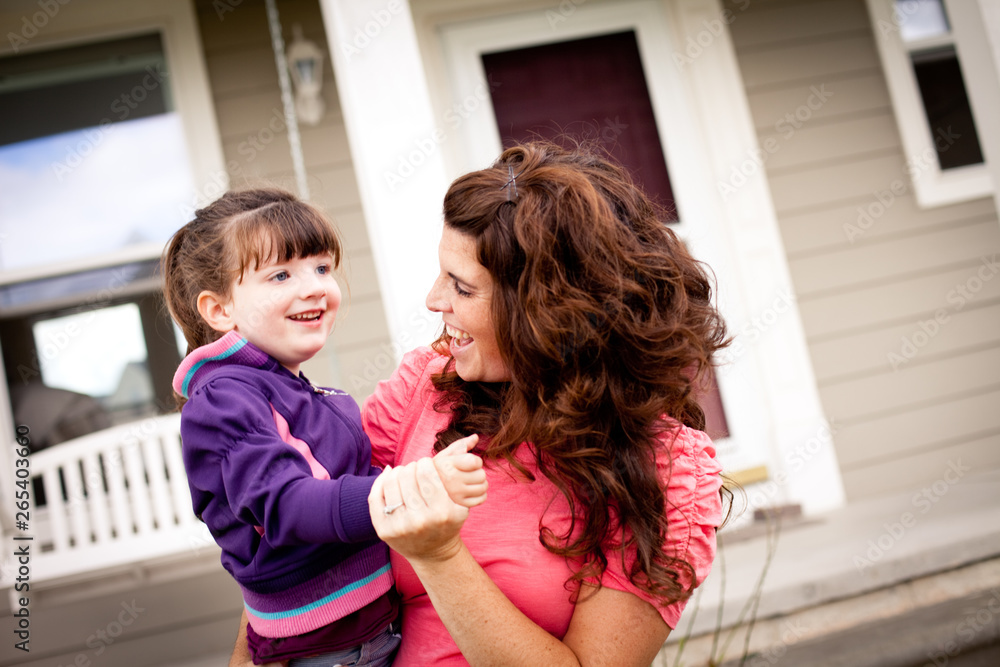 Happy Girl Dancing with Mother Outside Their Home