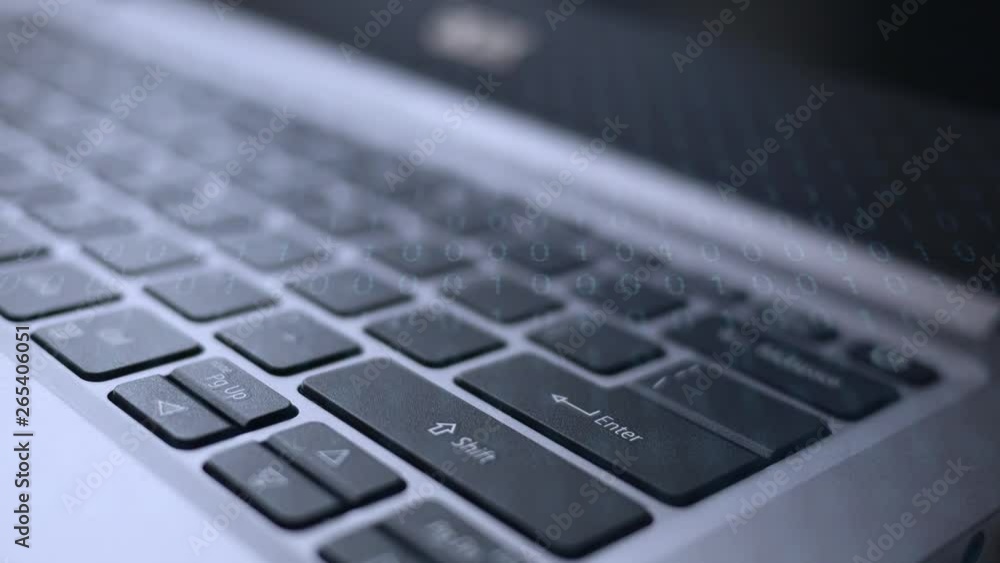 Finger dramatically presses the enter button on laptop with binary code overlay Finger dramatically presses the enter button on laptop with binary code overlay