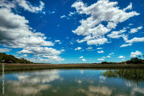 Puffy white clouds and blue sky over a salt-marsh at Pawleys Island.