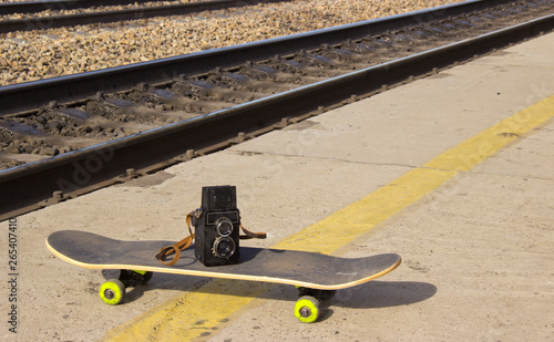 vintage camera on a skateboard on the background of asphalt